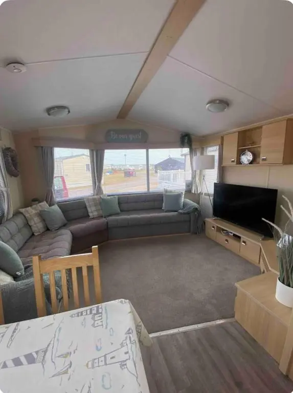 an rv living room with a couch and a table at Cozy\u2019s caravan hire in Lossiemouth