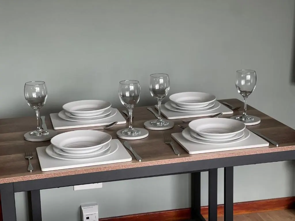 a table with plates and wine glasses on it at Meggies Place in Inverness