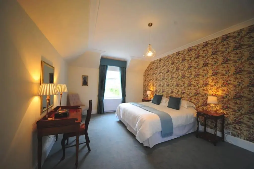 a bedroom with a bed and a desk and a window at Cray House - Large Country Home in Perthshire in Cray