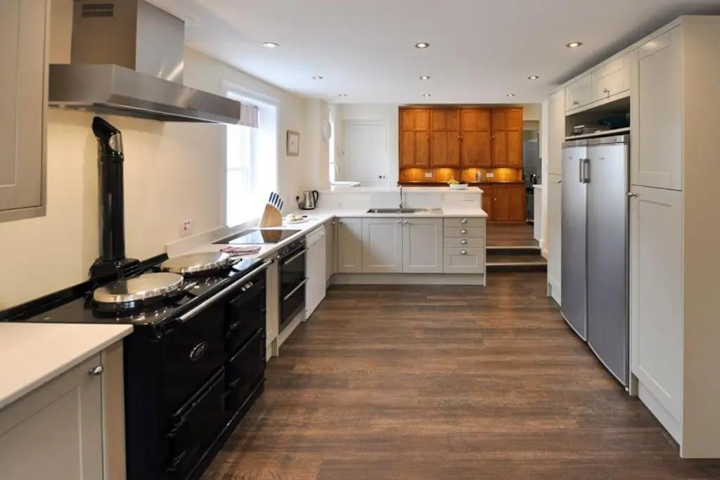 a kitchen with white cabinets and a black stove top oven at Cray House - Large Country Home in Perthshire in Cray