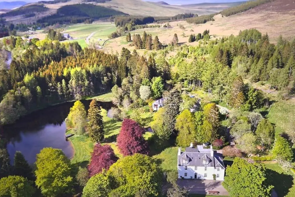 an aerial view of a house in the middle of a lake at Cray House - Large Country Home in Perthshire in Cray