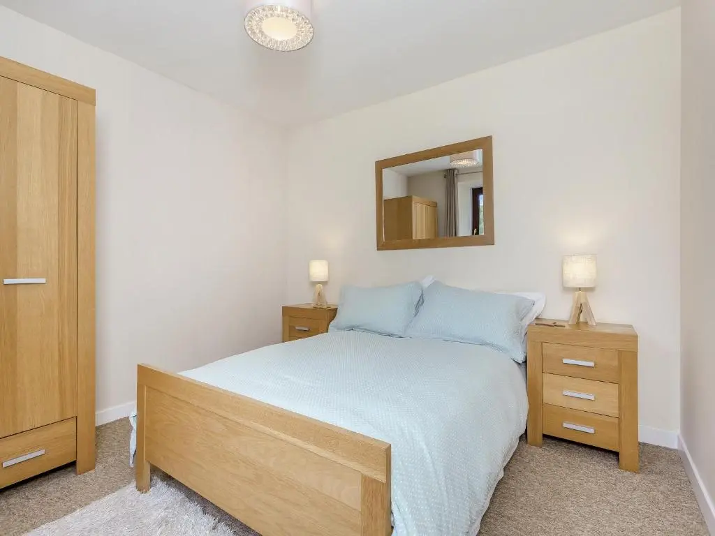 a bedroom with a bed and a mirror on the wall at Mid Bellandy in Ballindalloch