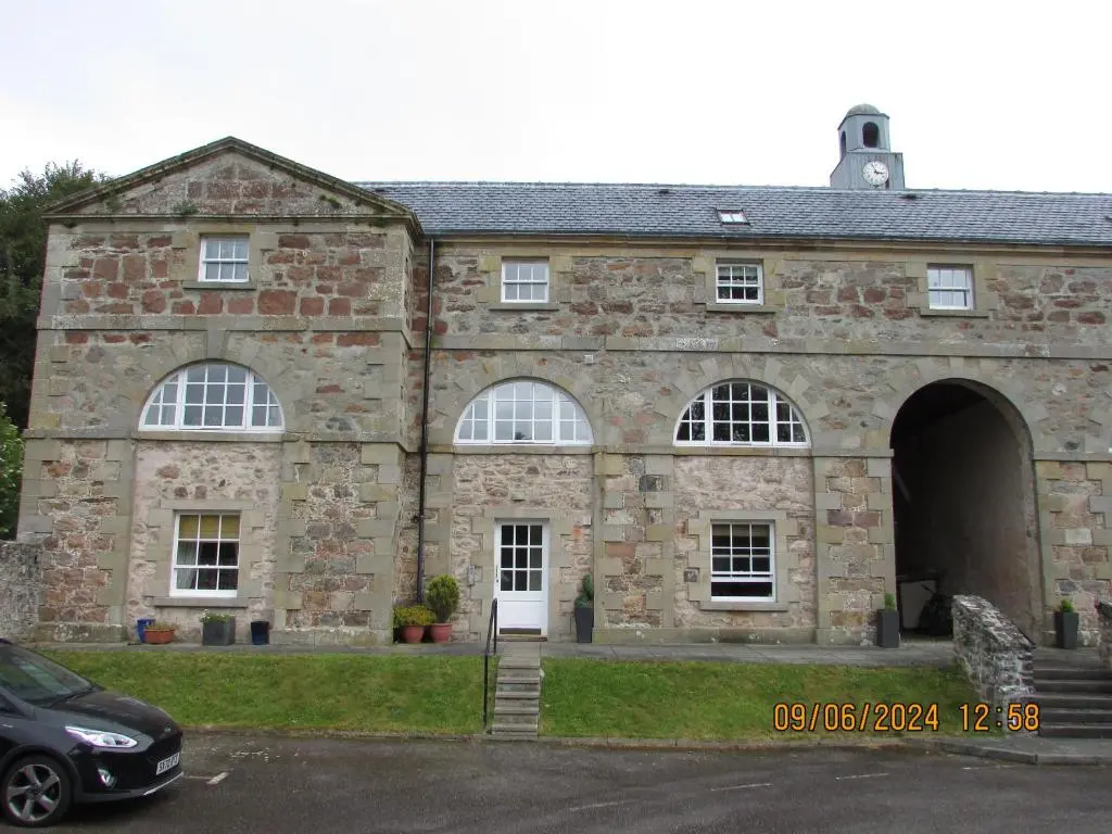 an old stone building with a car parked in front at Culloden Stables 4 in Inverness