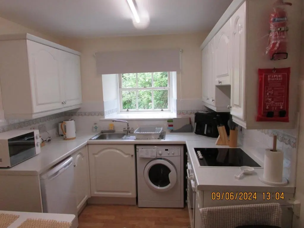 a kitchen with a washing machine and a sink at Culloden Stables 4 in Inverness