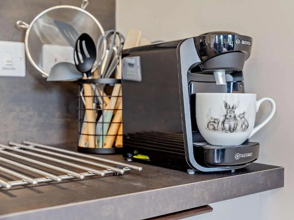 a coffee maker sitting on a counter with a cup at 2 Bed in Kiltarlity 95056 in Kiltarlty