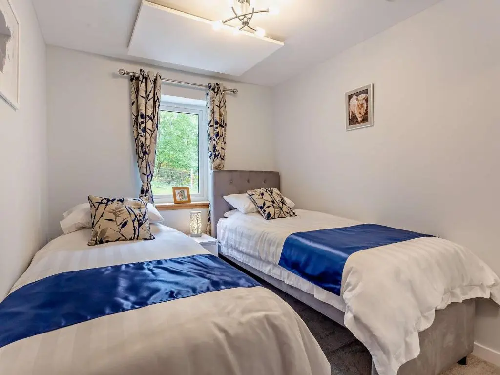 a bedroom with two beds and a window at 2 Bed in Kiltarlity 95056 in Kiltarlty