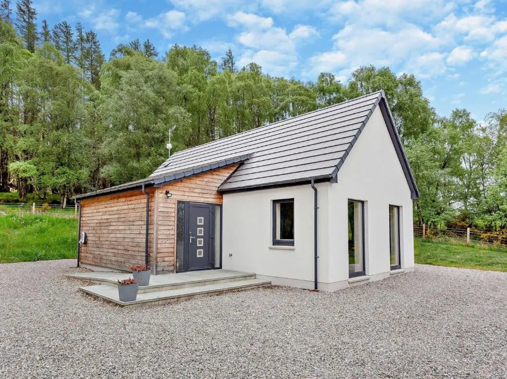 a small shed with a door on a gravel lot at 2 Bed in Kiltarlity 95056 in Kiltarlty