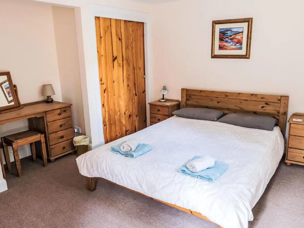 a bedroom with a bed with two towels on it at Holiday Home Old Stables by Interhome in Drumnadrochit