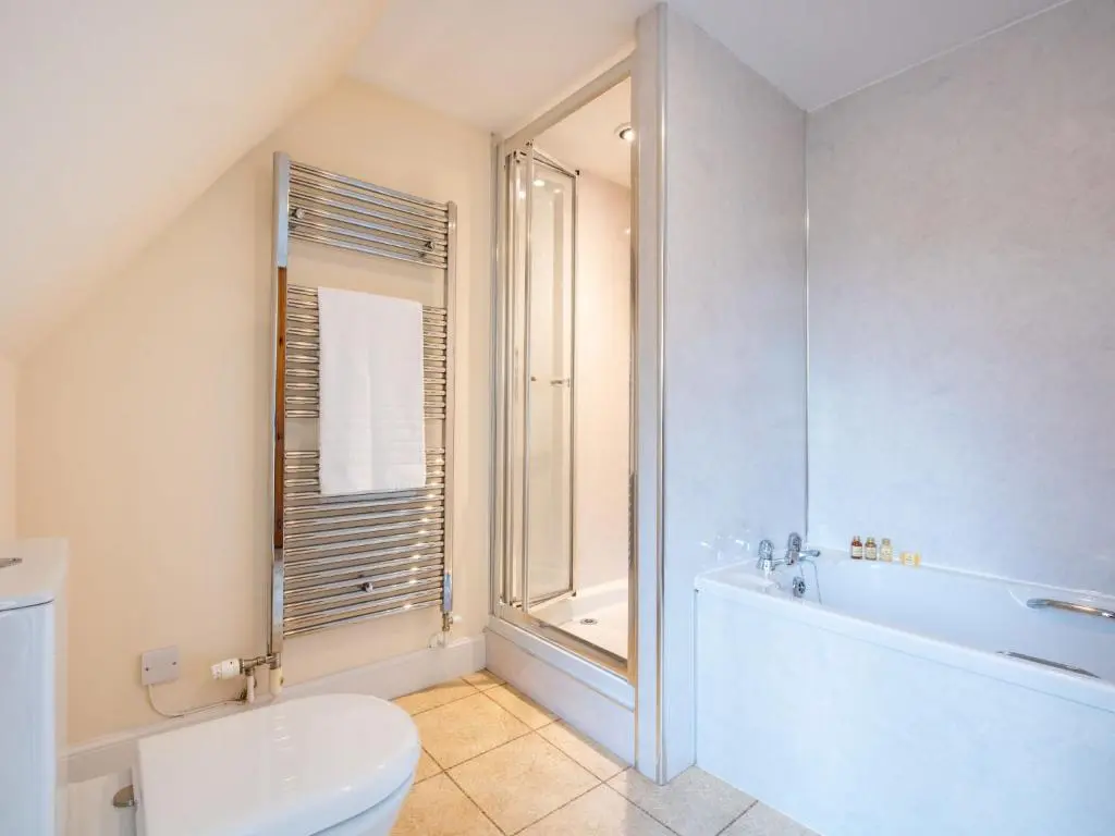 a white bathroom with a tub and a toilet at Holiday Home Old Stables by Interhome in Drumnadrochit
