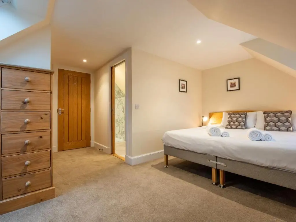 a bedroom with a large bed and a dresser at Holiday Home The Barn by Interhome in Drumnadrochit
