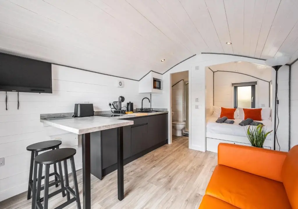 a kitchen and a living room with a bed at Alba Pod in Fort Augustus