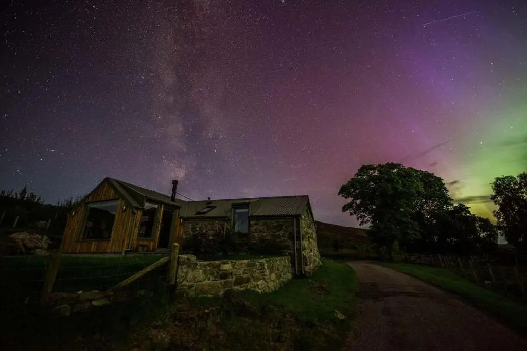 a house under a starry night with the milky way at The Stable Bothy in Rogart