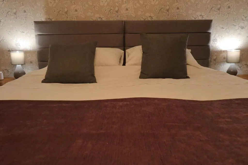 a bedroom with a large bed with two lamps at Fisherman's Rest in Helmsdale