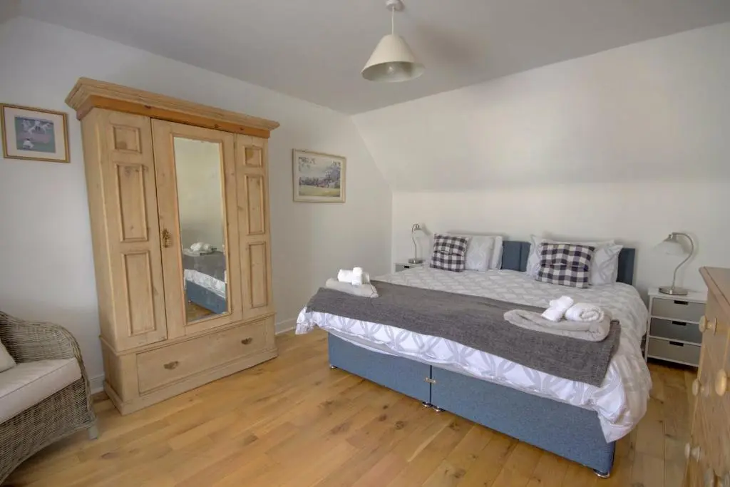 a bedroom with a bed with a dresser and a bed sidx sidx sidx sidx at Wilsons, Golspie in Golspie