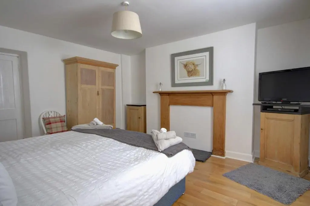 a bedroom with a bed and a flat screen tv at Wilsons, Golspie in Golspie