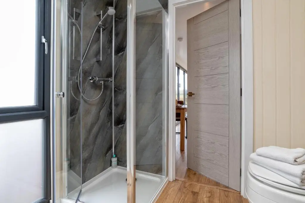 a bathroom with a shower with a glass door at The Off Grid Cabin in Insch