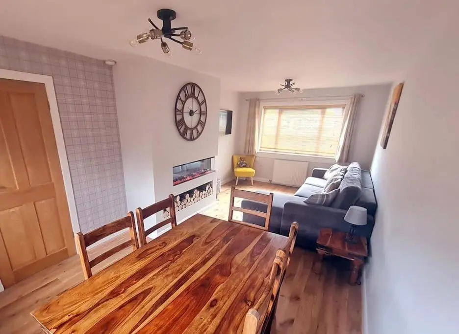 a living room with a couch and a table at York Street Retreat, modern cosy 2 bed with garden in Dufftown