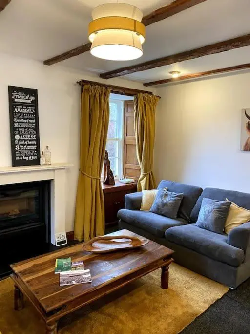 a living room with a couch and a coffee table at Historical North Cottage in Old Deer in Old Deer