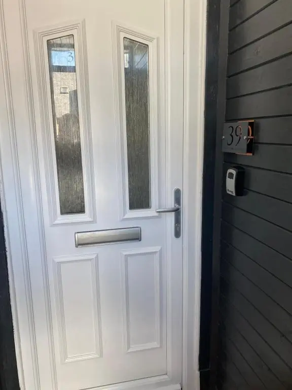 a white door with a window on a house at 39 Wells Street Apartment in Inverness