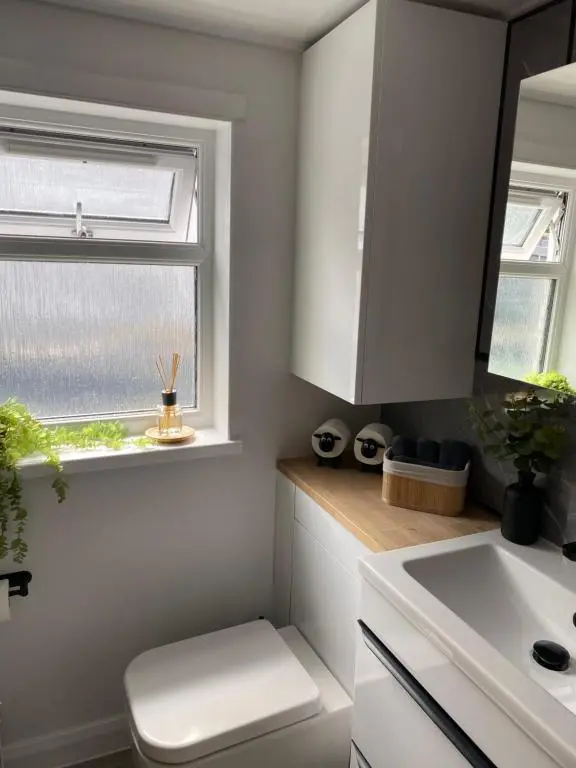 a kitchen with white cabinets and a window at 39 Wells Street Apartment in Inverness