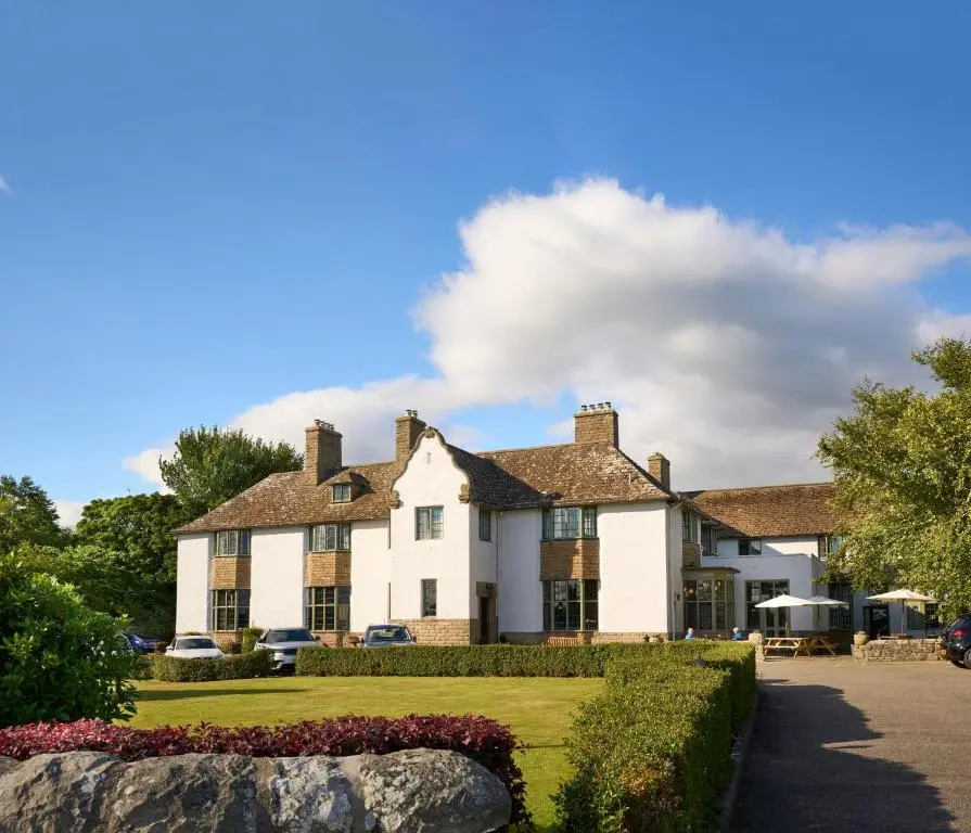a large white house with a garden in front of it at Royal Marine Hotel, by Highland Coast Hotels in Brora