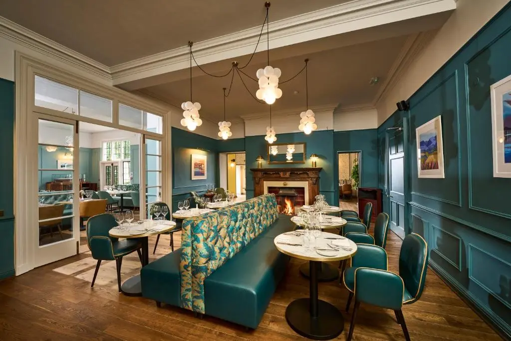 a restaurant with blue walls and tables and chairs at Royal Marine Hotel, by Highland Coast Hotels in Brora