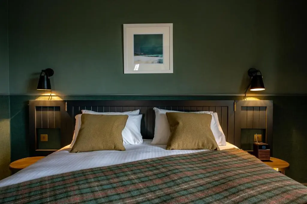 a bedroom with a large bed with two pillows at Royal Marine Hotel, by Highland Coast Hotels in Brora