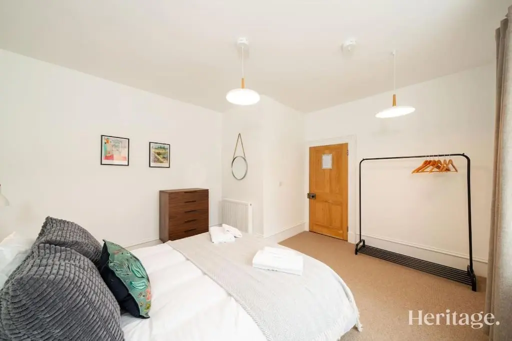 a bedroom with a white bed and a dresser at Kirkton Family Farmhouse with Hot Tub, Alford, Aberdeenshire in Alford
