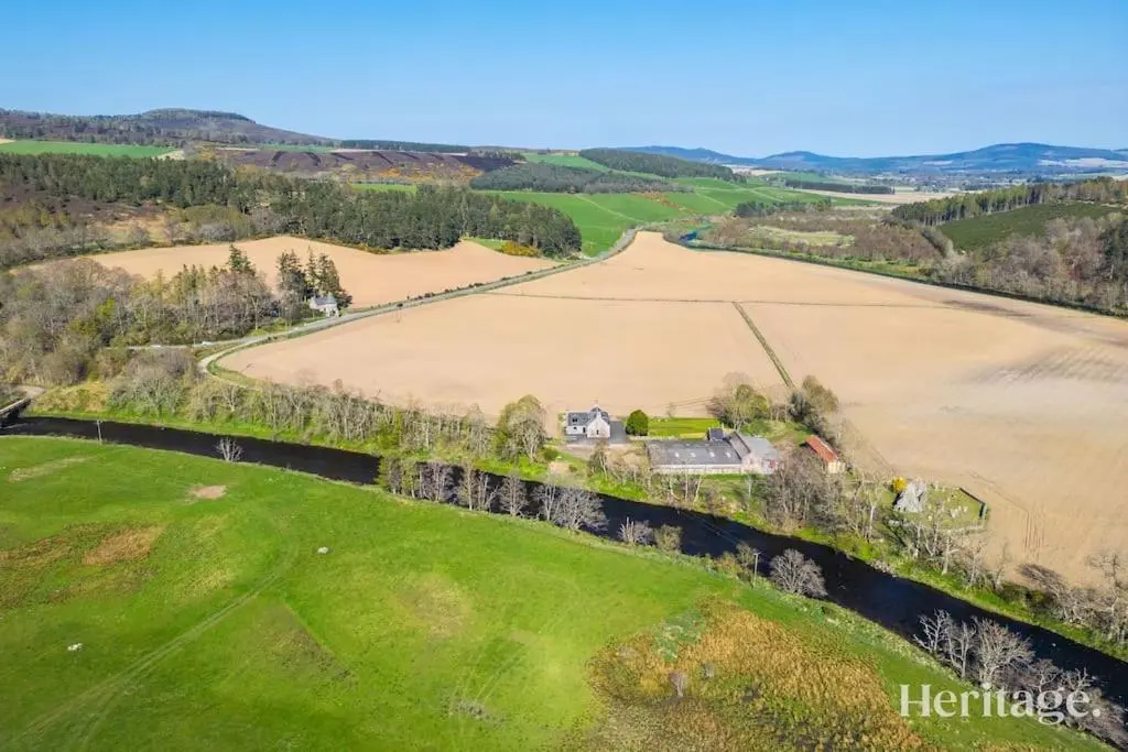 an aerial view of a farm and a field at Kirkton Family Farmhouse with Hot Tub, Alford, Aberdeenshire in Alford