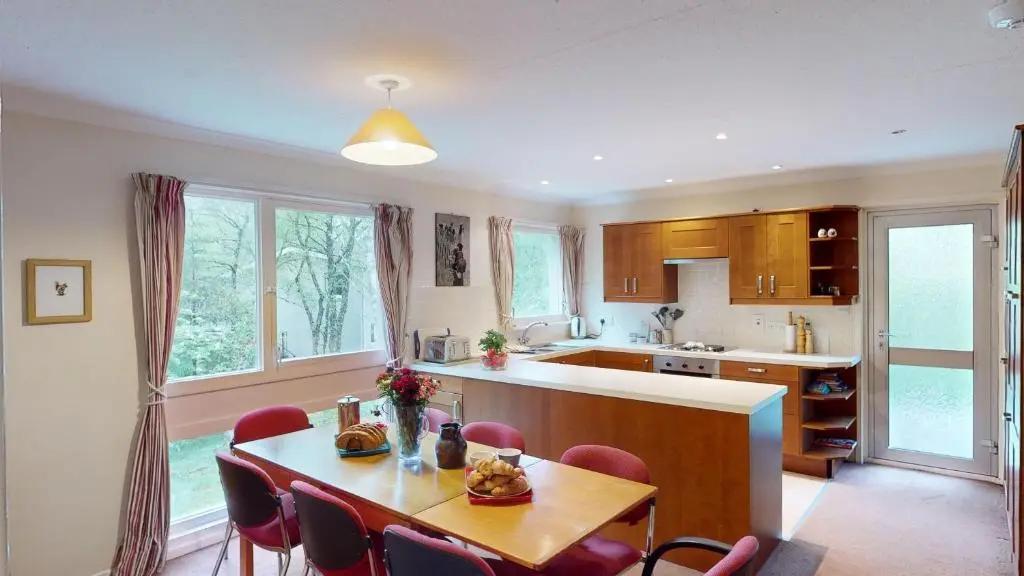 a kitchen and dining room with a table and chairs at Torr Beatha in Kincraig