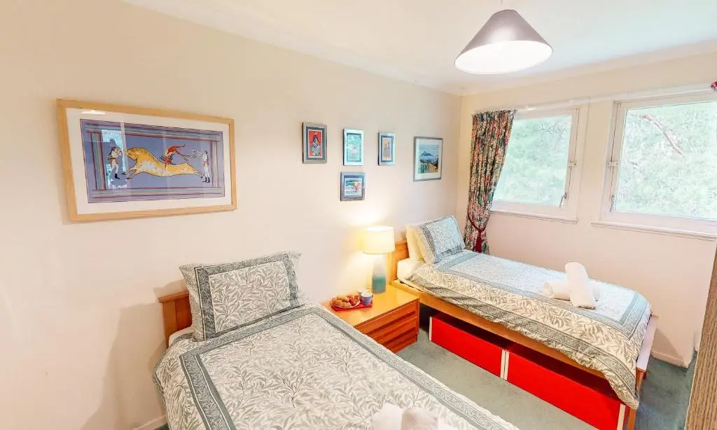 a bedroom with two chairs and a desk and a window at Torr Beatha in Kincraig
