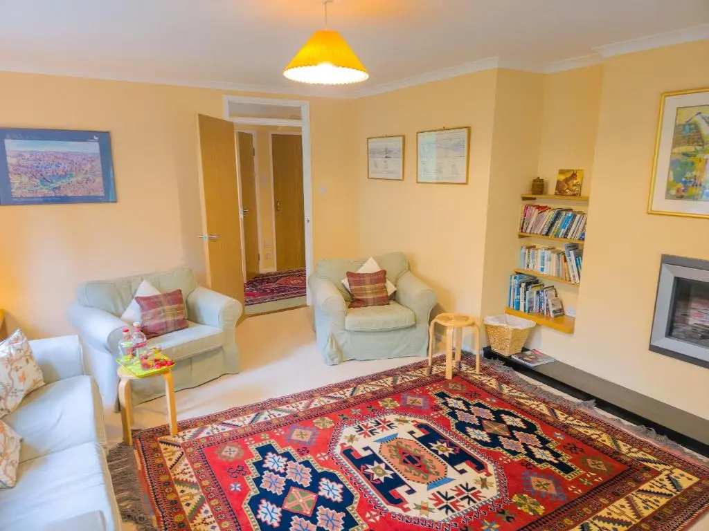 a living room with two chairs and a rug at Torr Beatha in Kincraig