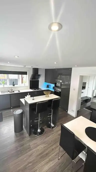 a large kitchen with a counter and a table at Stylish Highland Home in South Kessock