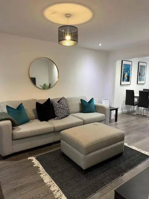 a living room with a couch and a mirror at Stylish Highland Home in South Kessock