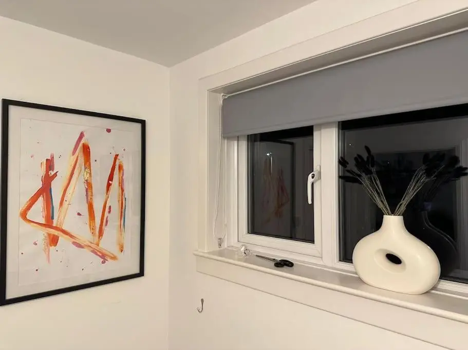 a window with a white vase on a window sill at Stylish Highland Home in South Kessock
