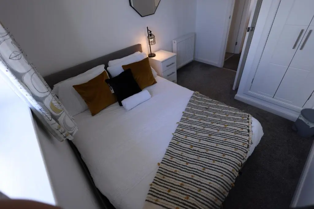 a bedroom with a bed with a metal headboard and pillows at Stylish Highland Home in South Kessock