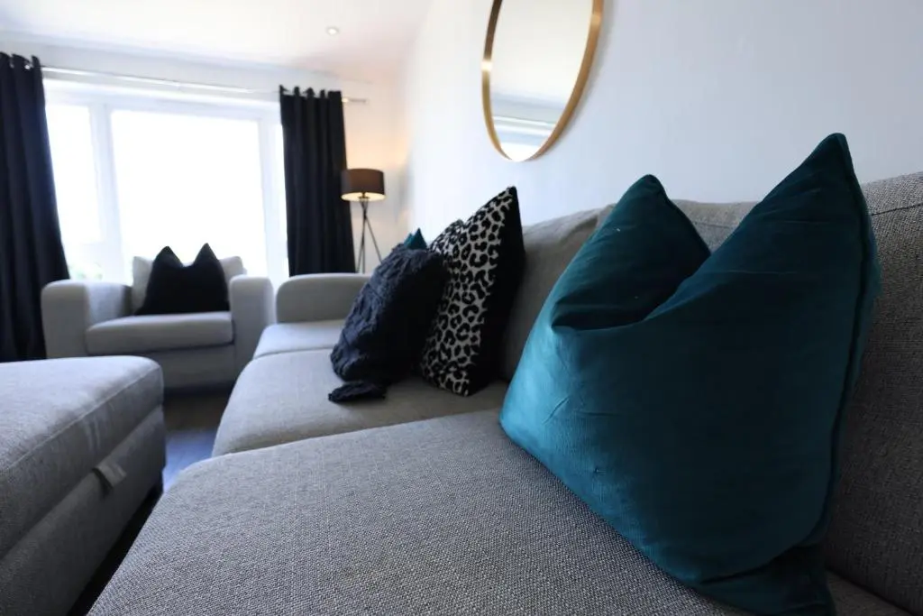 a living room with blue pillows on a couch at Stylish Highland Home in South Kessock
