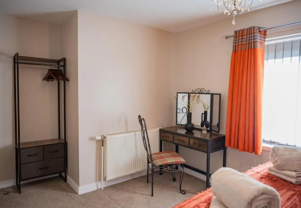 a bedroom with a desk and a bed and a mirror at North Coast Cottage - Coastal Highland Retreat with Sea Views in Portgower