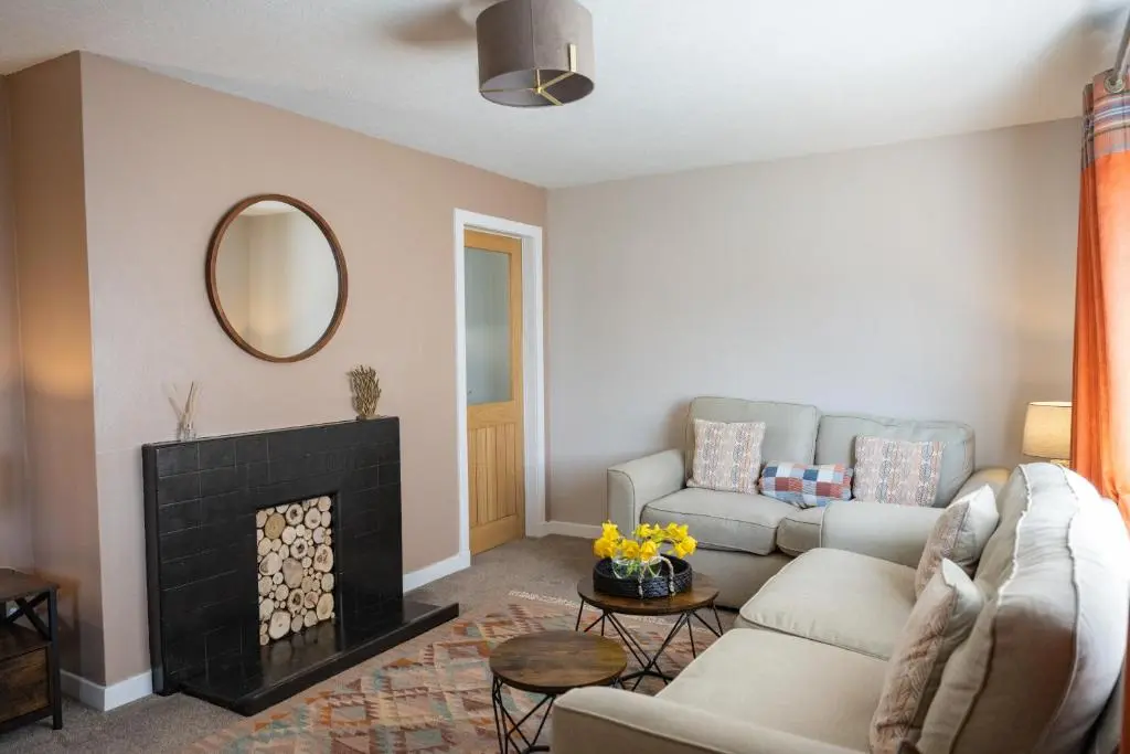 a living room with a couch and a fireplace at North Coast Cottage - Coastal Highland Retreat with Sea Views in Portgower