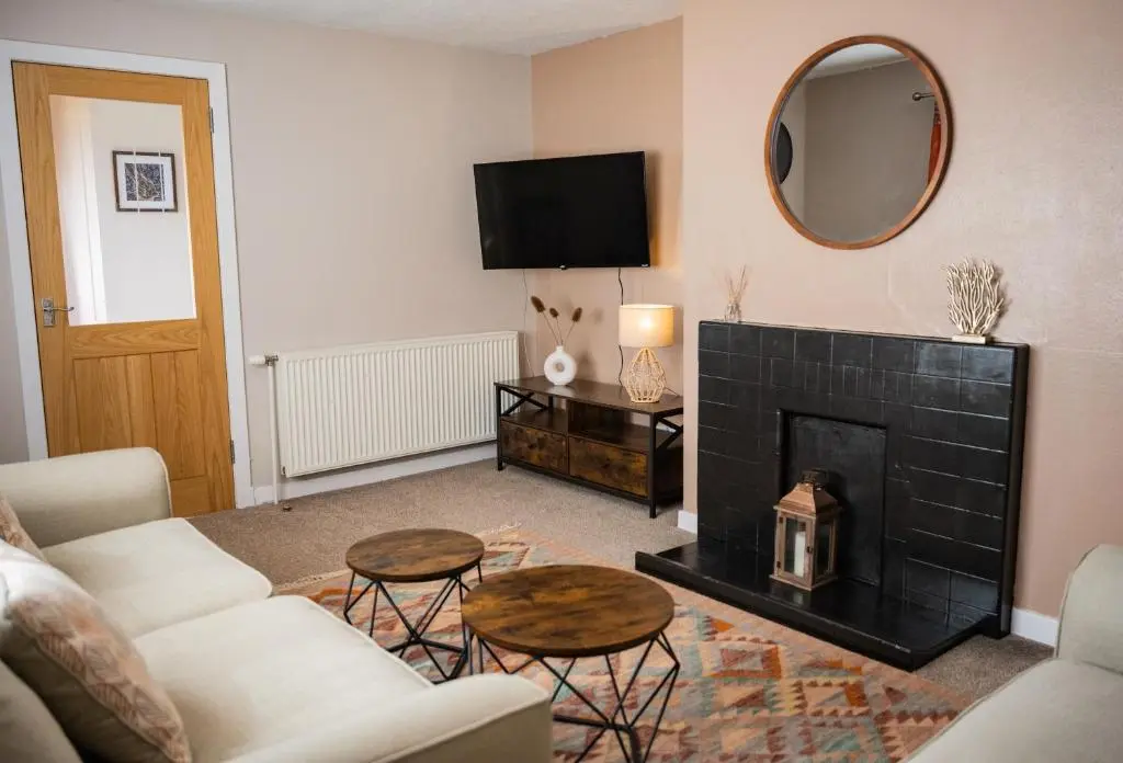 a living room with a fireplace and a mirror at North Coast Cottage - Coastal Highland Retreat with Sea Views in Portgower
