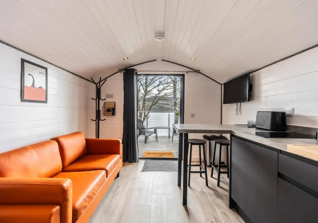 a living room with a couch and a table at Nessie Pod in Fort Augustus