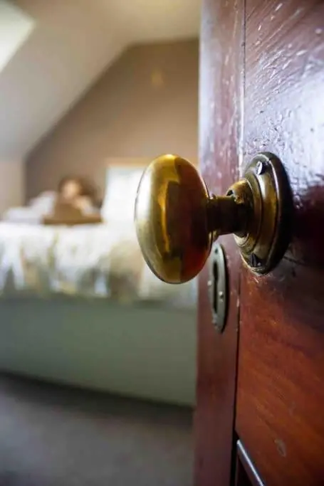 an open door with a person in a bed at Crannoch Self Catering - 10 bedroom former hotel in Cullen