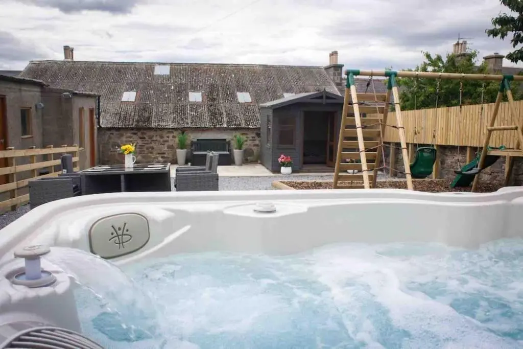 a jacuzzi tub in the backyard of a house at Crannoch Self Catering - 10 bedroom former hotel in Cullen