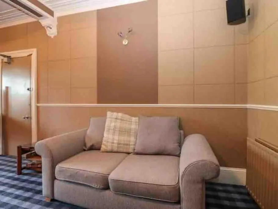 a living room with a couch in a room at Crannoch Self Catering - 10 bedroom former hotel in Cullen