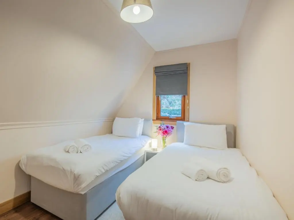 two beds in a small room with a window at Chalet Loch Lochy Retreat by Interhome in Spean Bridge