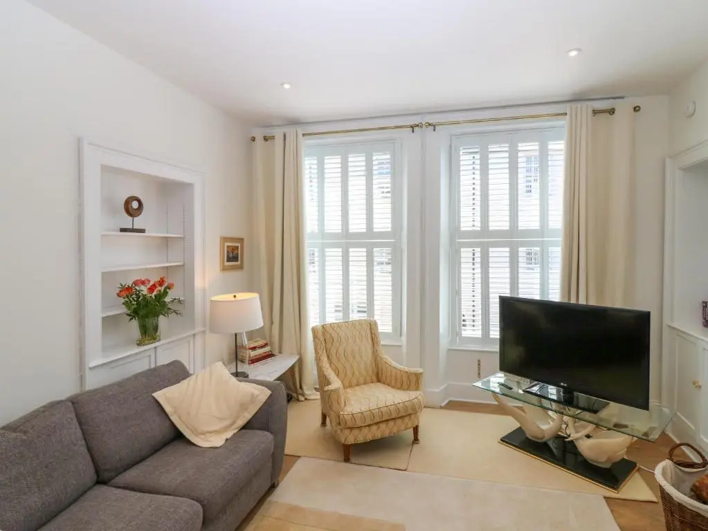 a living room with a couch and a tv at 1A Carmelite Street in Banff
