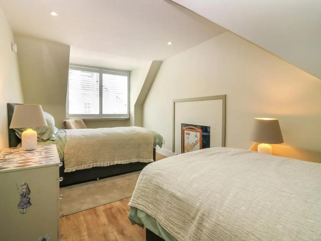 a bedroom with two beds and a window at 1A Carmelite Street in Banff