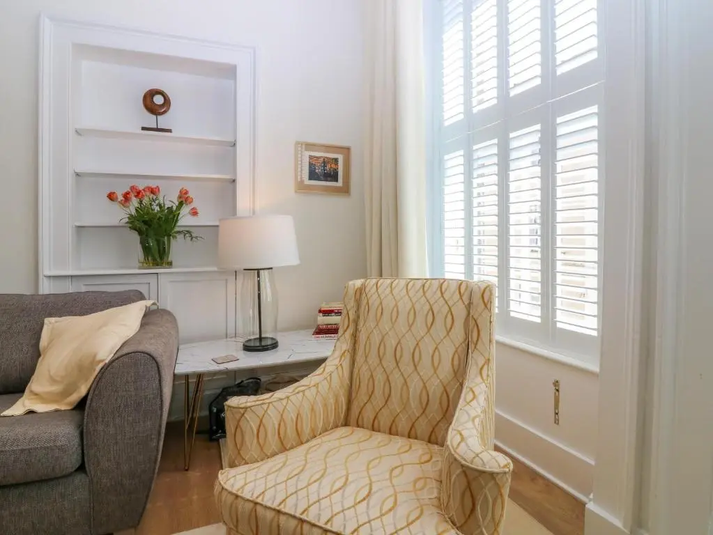 a living room with a chair and a desk at 1A Carmelite Street in Banff
