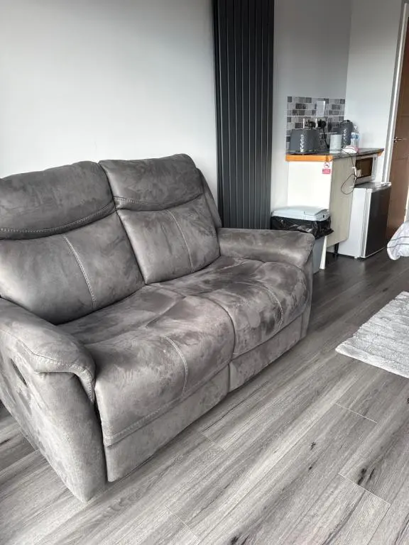 a brown leather couch in a living room at Wee Coastal Snug in Wick