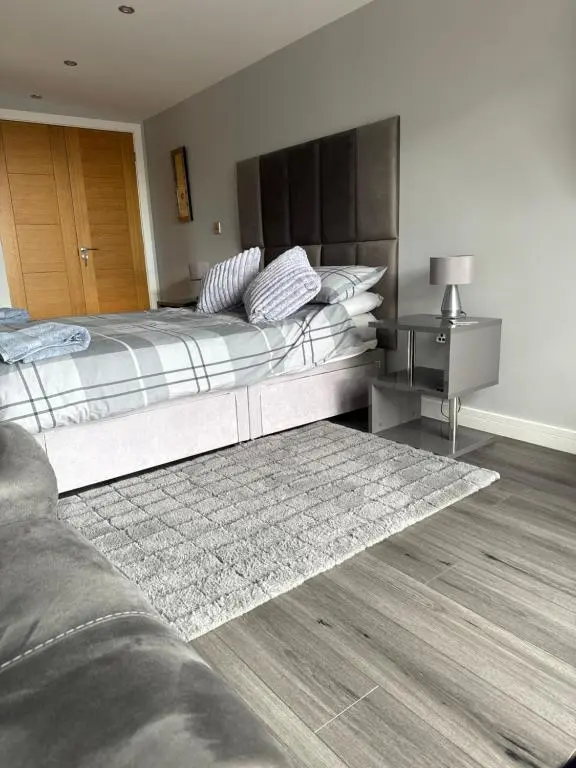 a bedroom with two beds and a rug at Wee Coastal Snug in Wick